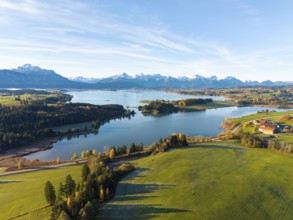Rural scene with vast meadows and a lake, framed by mountains, Illasbergsee, Forggensee, near