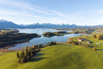Picturesque landscape with a lake and mountains surrounded by green fields, Illasbergsee,