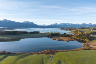 Wide landscape with lake surrounded by mountains and autumn trees under clear skies, Illasbergsee,