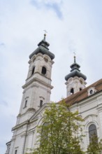 Two tall baroque church towers with crosses in the background of a cloudy sky, ZFP Zwiefalten,