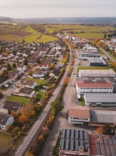 A Hermann Hesse Railway line surrounded by autumnal fields and industrial buildings in a rural
