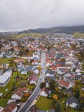 Small village, seen from above, surrounded by autumn leaves. Foggy horizon and hilly landscape,