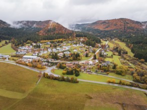 Extensive autumn landscape with a small village nestled between fog-covered hills, Wehingen,