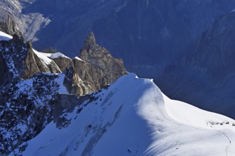 Rugged rocks jut out of a snow-covered mountain, viewing platform, Aiguille du Midi mountain