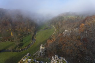Autumn landscape with rising fog over the Grosse Lauter river loop in Lautertal at sunrise. View