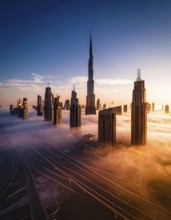 City scape emerging from a dense enveloping fog in sunrise and skyscrapers piercing the haze, big