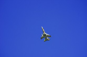 A single-jet fighter jet during a flight demonstration as part of an air show at the Rossfeld Air