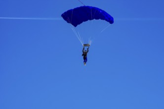 Skydivers during an aerial acrobatic performance as part of an air show at the Fliegerbergfest of