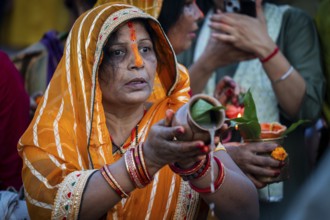 Hindu devotees offer prayers to the Sun God on the bank of Brahmaputra river on the occasion of