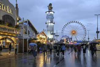 Oktoberfest visitors with umbrellas, rainy meadows, Löwenbräuturm, Ferris wheel, Munich, Bavaria,