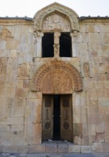 Historic stone wall with carved door and religious symbols, Noravank monastery, Surb Karapet