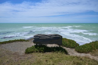 Wooden bench with sea view under cloudy sky, Tuhawaiki Point Lighthouse or Jack's Point Lighthouse,