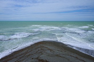 Sea with foaming waves and cloudy sky, Tuhawaiki Point Lighthouse or Jack's Point Lighthouse,