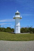 White lighthouse in a meadow next to the coast, Tuhawaiki Point Lighthouse or Jack's Point