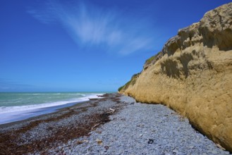 Cliff with pebble beach and blue sky on a sunny day, Tuhawaiki Point Lighthouse or Jack's Point