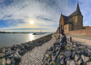 Photo with melancholy mood of bronze sculpture Poortekerl looking at Rhine waiting for ship to