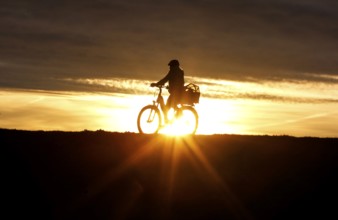Cyclists ride on a cycle path on the island of Fehmarn at sunset, 13.10.2025, Fehmarn,