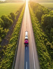 Petrol cargo truck lorry tanker driving on highway hauling oil products at sunrise, wide hilly