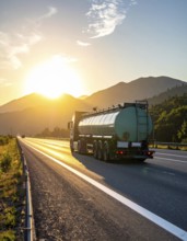 Petrol cargo truck lorry tanker driving on highway hauling oil products at sunrise, wide hilly