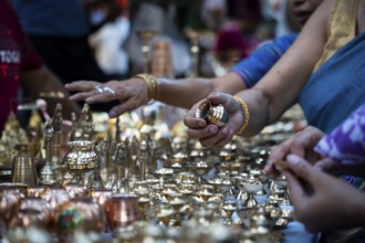 People shop for bronze and other metal items at a roadside stall on Dhanteras, in Guwahati, Assam,
