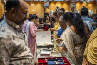 Customers purchase Gold jewelry at a store on the occasion of the festival of Dhanteras, in