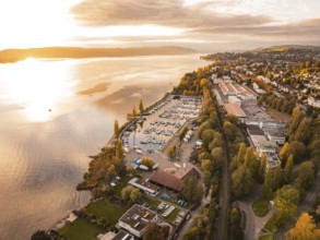 Harbour with boats on an autumn evening at sunset, surrounded by an urban landscape, Überlingen,