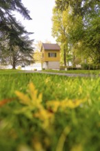 Small yellow house in an autumnal park on a sunny day, Überlingen, Lake Constance, Germany
