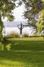 A statue in a park surrounded by trees and green grass with an autumnal atmosphere, Überlingen,