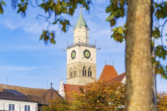 Church tower against blue sky with autumn leaves in the foreground, Überlingen, Lake Constance,