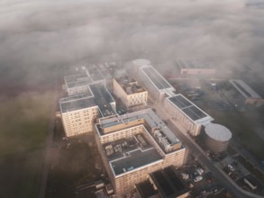 Aerial view of an industrial complex in morning fog with thick cloud cover, new hospital health