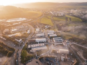 Sunrise over a village with adjacent fields and winding roads, new hospital health campus building,