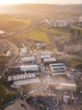 Aerial view of a village in morning light surrounded by rolling fields, new hospital health campus