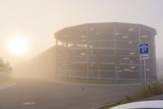 Misty street with parking garage at sunrise, mystical atmosphere, new hospital health campus