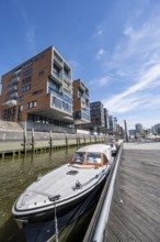 Modern residential buildings, boats at the traditional shipping harbor on Sandtorkai, behind
