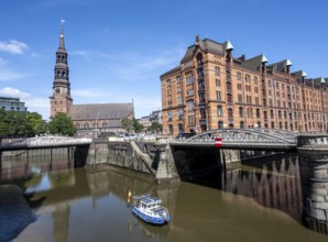 Boat on the Kleines Fleet canal with Kannengießer bridge and tower of the main church of St.