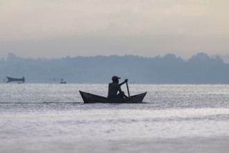 Fisherman in a rowing boat, silhouette, morning mood, Mabamba Swamp, Lake Victoria, Uganda