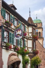 Decorated half-timbered house with guild sign of a patisserie in the old town centre of Kaysersberg