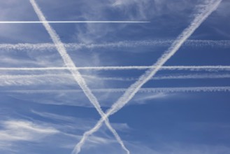 Contrails in the sky. These artificial clouds are created from the exhaust fumes of aeroplanes. But