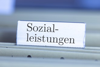 (Photomontage) Sign with the inscription SOZIALLEISTUNGEN on a suspension file index