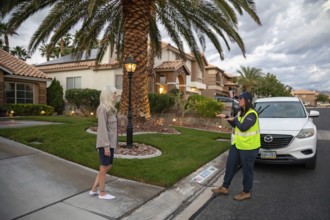 Las Vegas, Nevada - Devyn Choltko, a water waste investigator, talks to a resident about water use