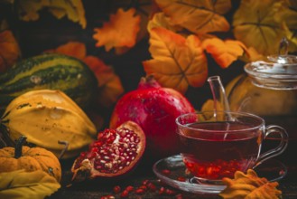 Tea served in a glass cup with pomegranate and autumnal background