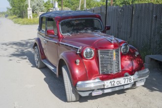 Red vintage car parked on a dusty road in the sunshine, Moskvich 401, Armavir province, Armenia