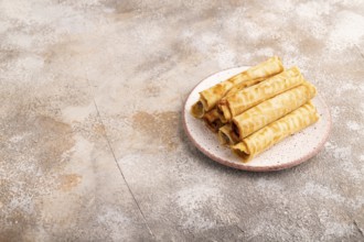 Waffles with caramel on brown concrete background, side view, copy space