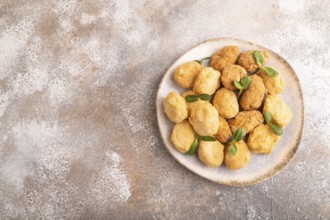 Fried crispy Chicken Nuggets with ketchup, microgreen on brown concrete background. top view, flat