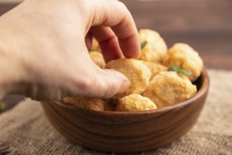Fried crispy Chicken Nuggets with ketchup, microgreen on brown wooden background and linen textile