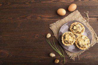 Tartlets with meat and cheese on brown wooden background and linen textile. top view, flat lay,