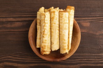 Waffles with caramel on brown wooden background, top view, flat lay, copy space