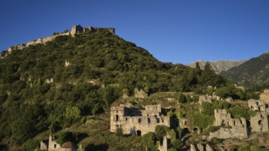 Drone image, Byzantine castle perched on a wooded hill under a blue sky, Mystras, Mistra, UNESCO