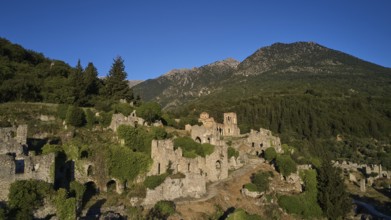 Drone shot, Historical ruins in a hilly landscape with a clear blue sky, Church of Agia Sophia from