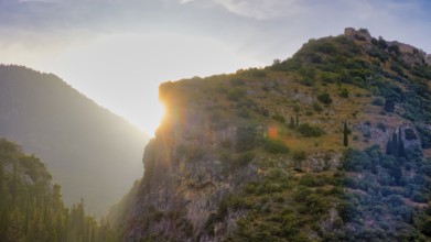 Byzantine castle from the 13th century AD, sun rays break through a rocky mountain landscape bathed
